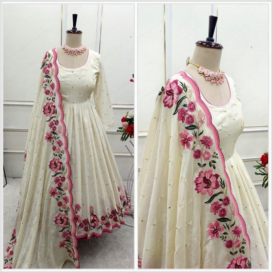 Elegant off-white ethnic Anarkali dress with golden polka dots and pink floral embroidered dupatta on mannequin