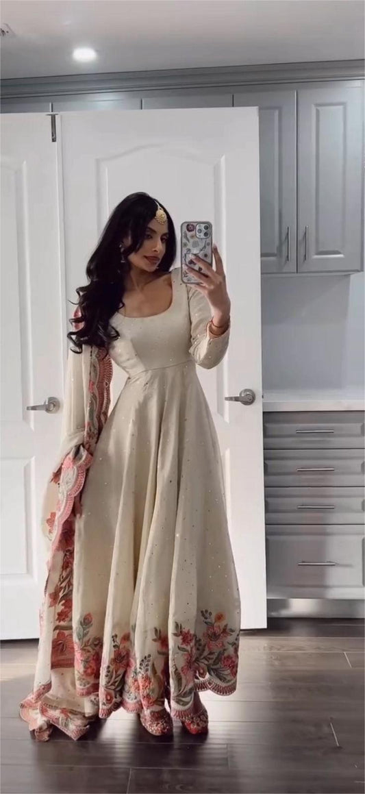 Woman taking mirror selfie wearing beige ethnic anarkali dress with floral embroidery and matching dupatta