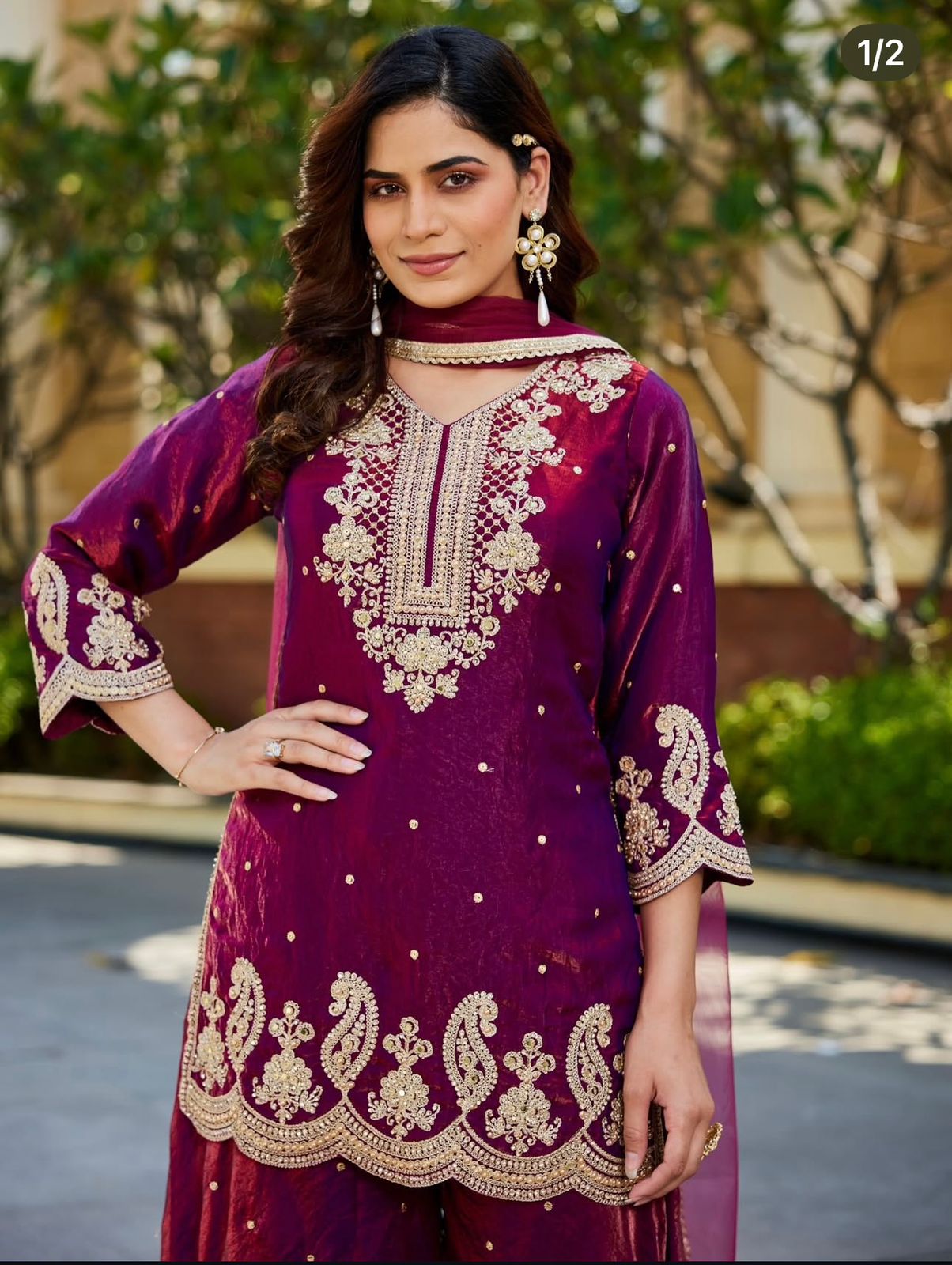Woman wearing a purple ethnic kurti with intricate gold embroidery and matching earrings outdoors