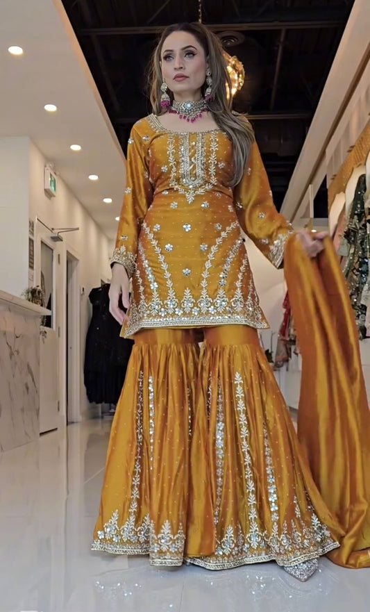 Mustard yellow Chinnon silk embroidered sharara suit set with dupatta designer ethnic wear front view - WishTown Fashion Club