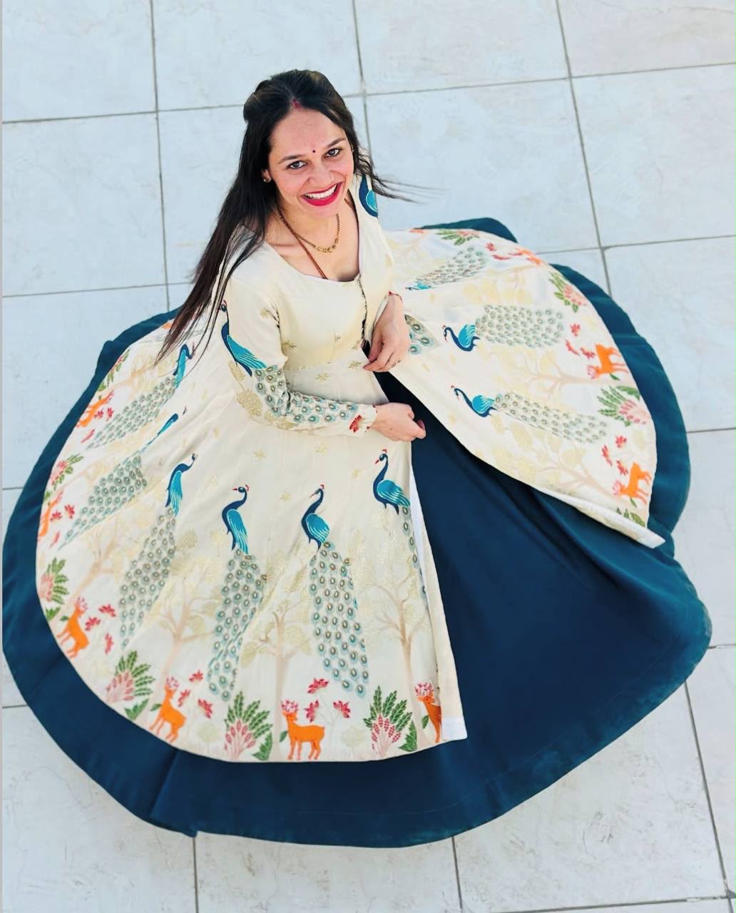 Front view of full three piece peacock blue ethnic outfit displaying an embroidered shimmer silk crop top shrug and a heavy flared skirt.