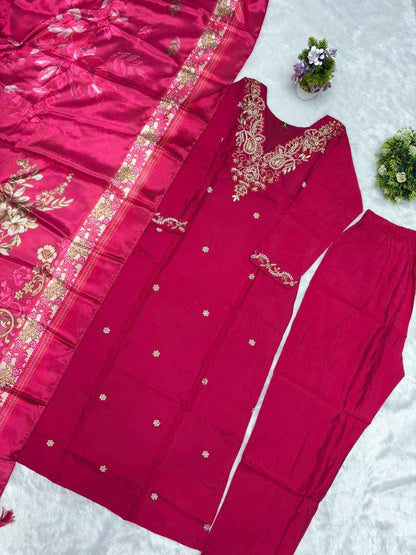 Close up view of detailed hand embroidery work and delicate val moti embellishments on the neckline of a pink roman silk fabric.