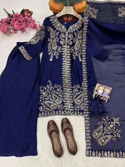 Focused overhead display of the embroidered neckline details and fine needlework finishes on the navy blue silk top.