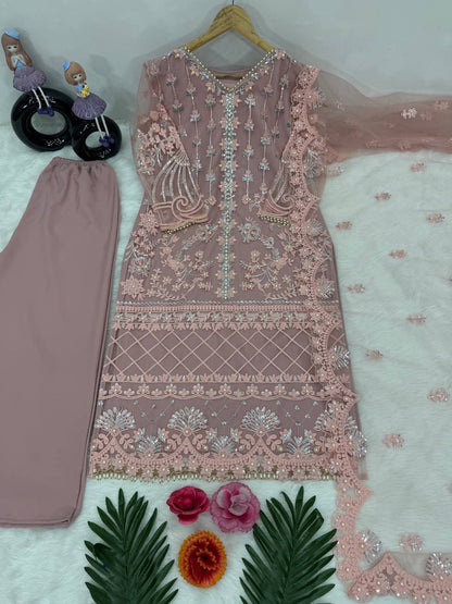 Side perspective of a fully stitched dusty rose festive dress highlighting the sheer net sleeves and smooth interior cotton lining.