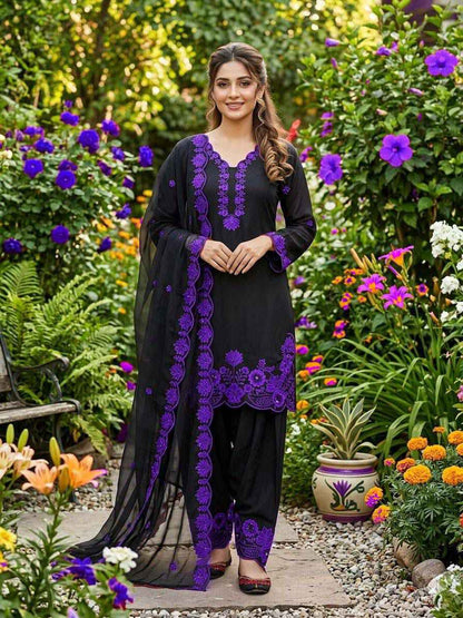 Front view of a dark purple festive wedding outfit featuring a long embroidered silk tunic top and wide leg salwaar pants.