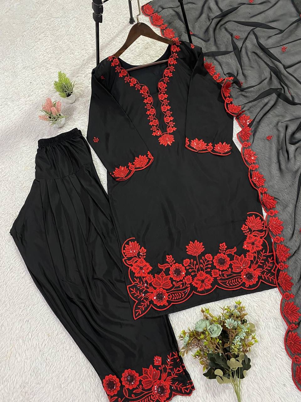 Side perspective of a fully stitched red traditional outfit showcasing the sheer soft organza dupatta with shimmering border detailing.