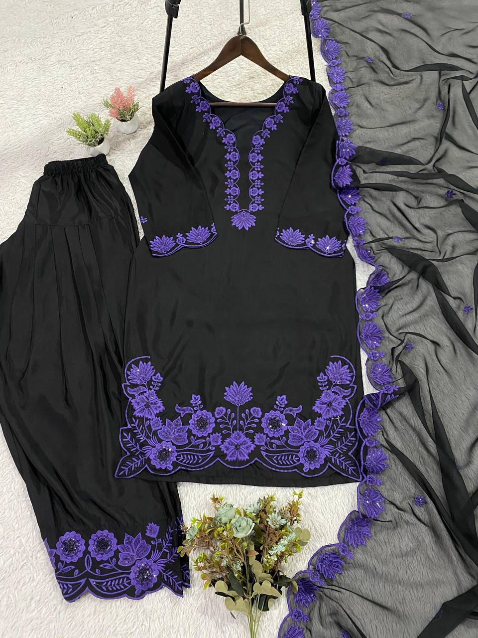 Detailed close view of shimmering sequence work and metallic thread decorations on a deep magenta purple top bodice fabric.