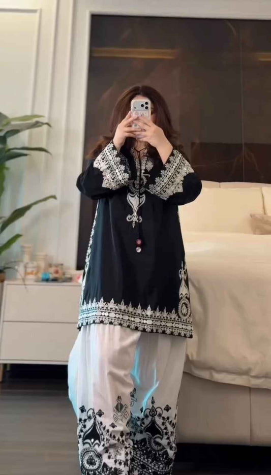 Front view of full three piece black traditional festive outfit displaying an embroidered pure natural crepe silk tunic and wide leg farshi trousers.