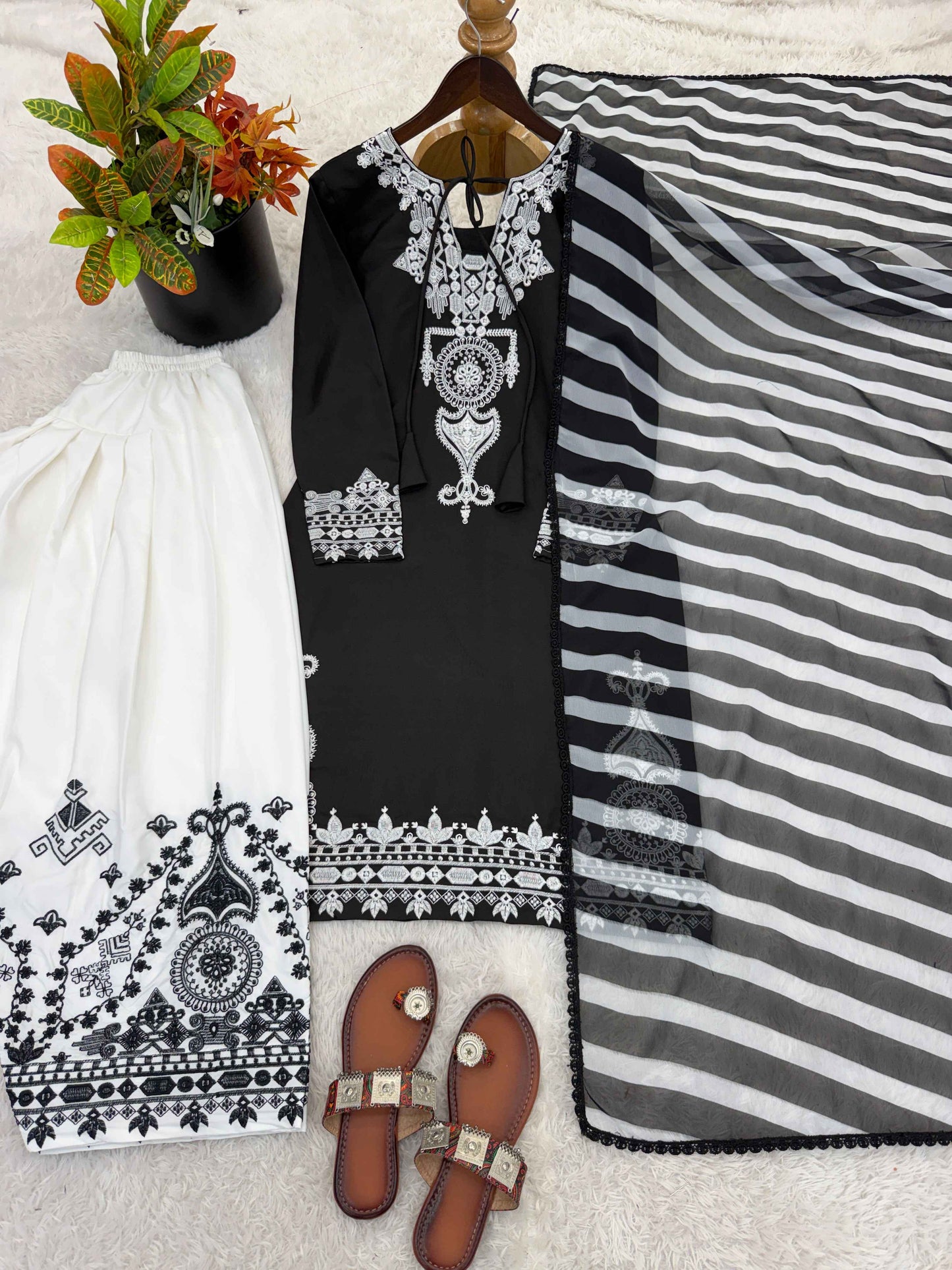 Side perspective of a fully stitched black ethnic dress highlighting the elegant full length sleeves and flowing digital printed georgette dupatta.