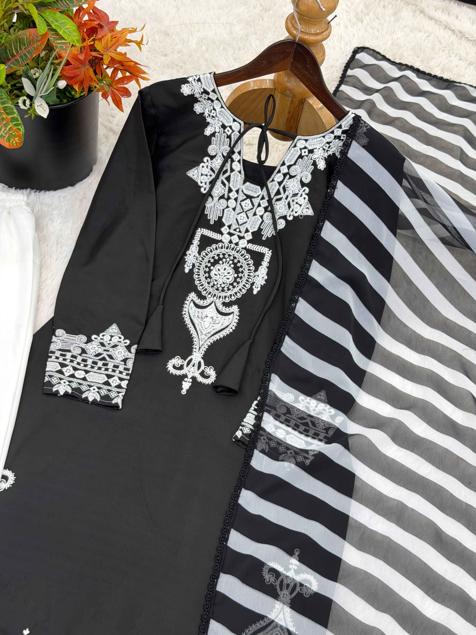 Close up view of detailed traditional embroidery work and fine stitching patterns on the luxurious smooth surface of a black crepe silk bodice.