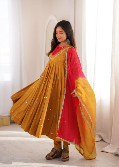 Close up view of detailed sequence embroidery work and sparkling real mirror embellishments on a bright mustard yellow roman silk fabric.