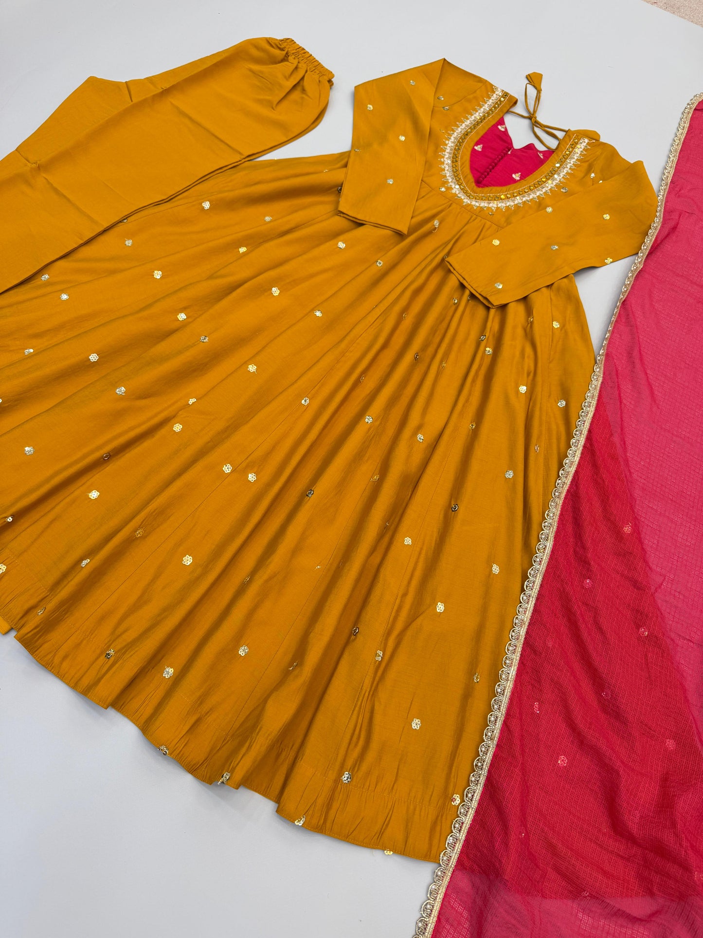Complete flat layout presentation of the designer mustard yellow suit set displaying the three separate pieces including gown pants and scarf.