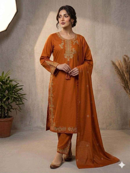 Front view of full three piece rust orange traditional festive outfit showcasing an embroidered silk tunic top and wide leg palazzo trousers.