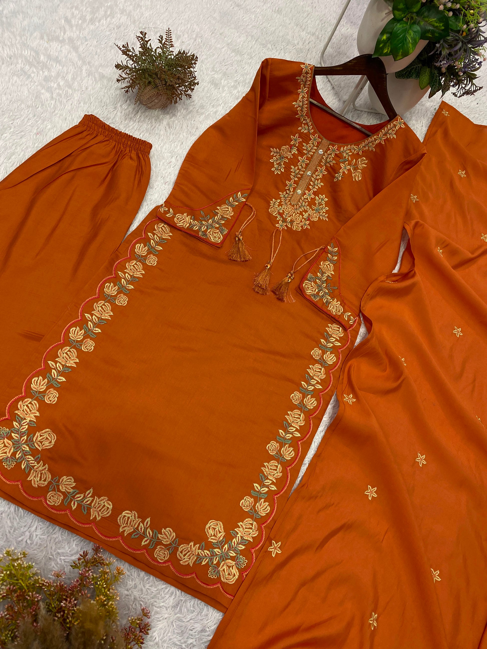 Side perspective of a fully stitched rust orange ethnic suit highlighting the clean tailored seams and fluid fabric drape.