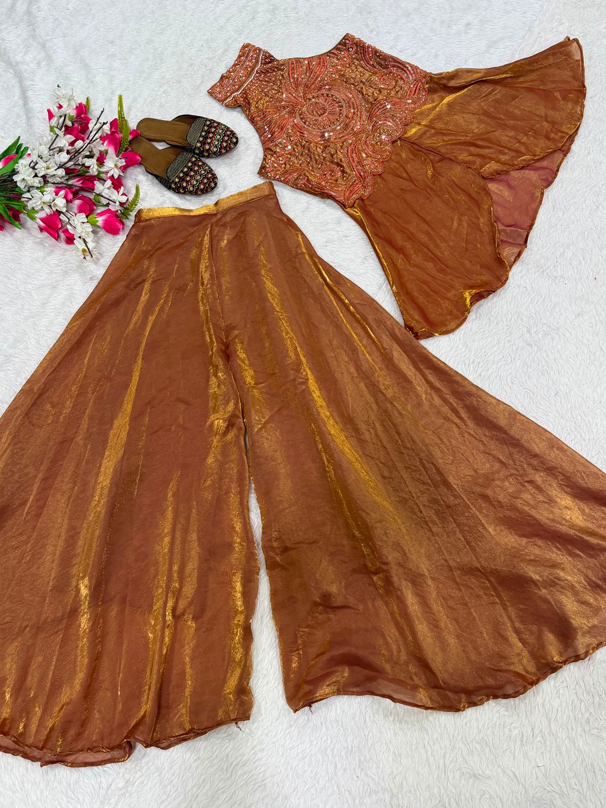Close up view of detailed heavy beads hand work and elegant white moti work embellishments on a rich brown fandy silk neckline.