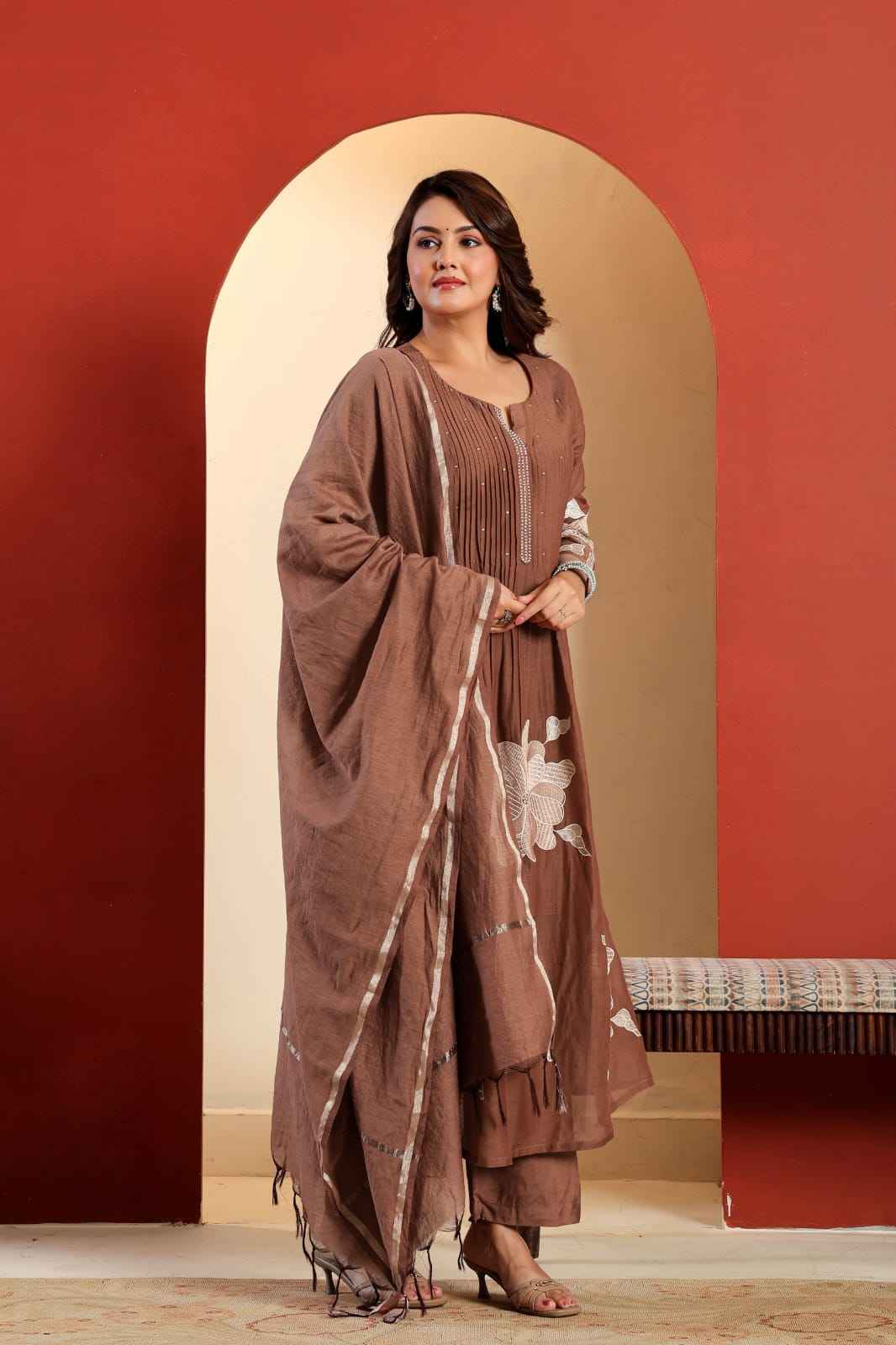Close up view of detailed luxury traditional hand work embroidery sequence stitching and premium moti work accents on a rich brown cotton yoke.