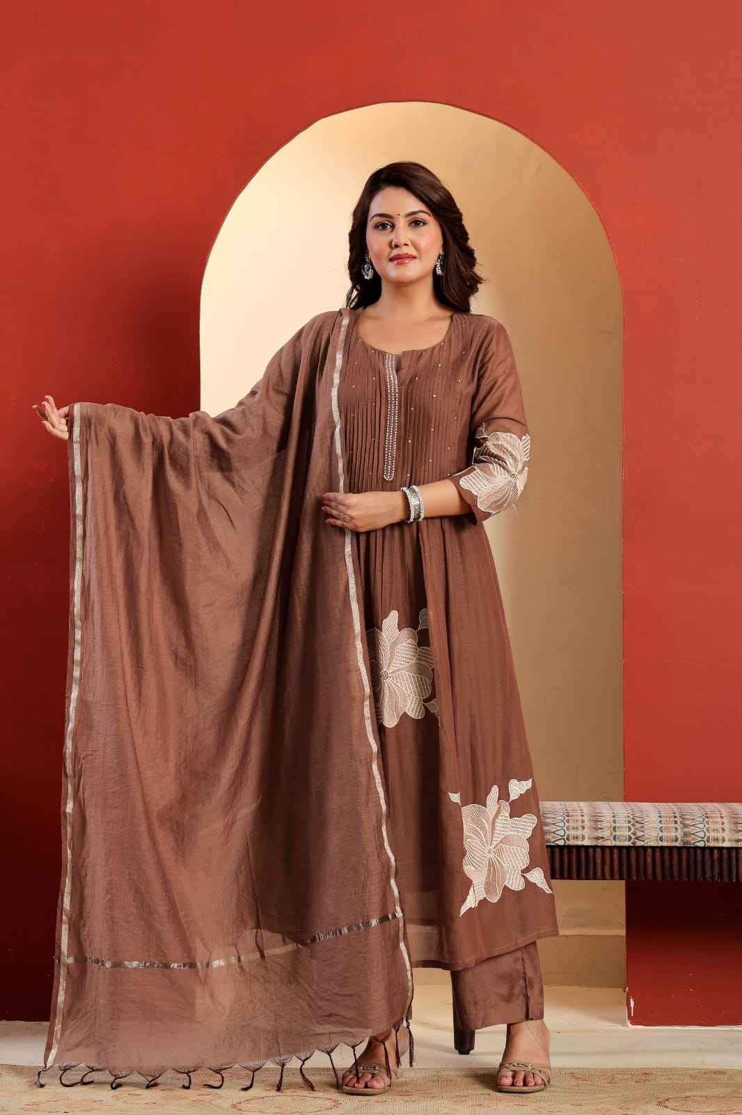 Front view of full three piece brown embroidered cotton hand work kurti set displaying a sequence moti work tunic top palazzo trousers and chanderi silk golden line dupatta.