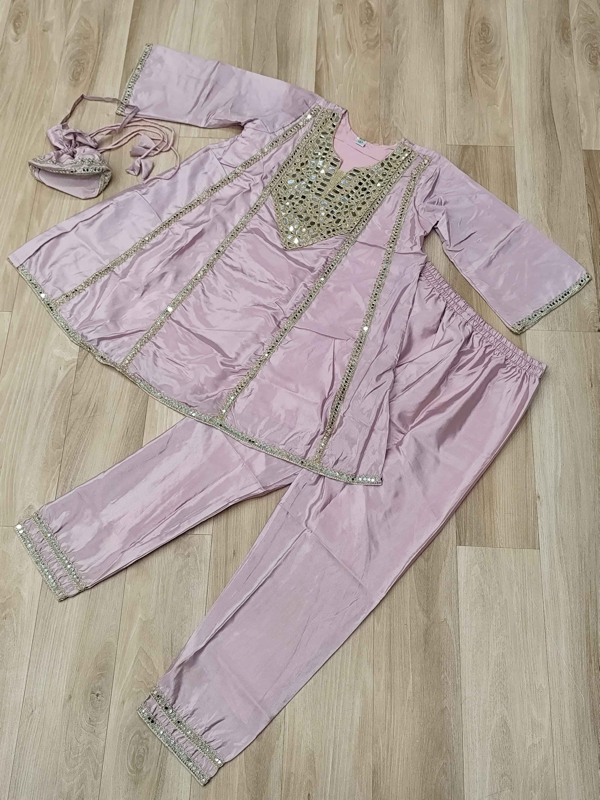 Close up view of authentic reflective real mirror work patterns and shimmering embroidered details on a soft pink neckline.