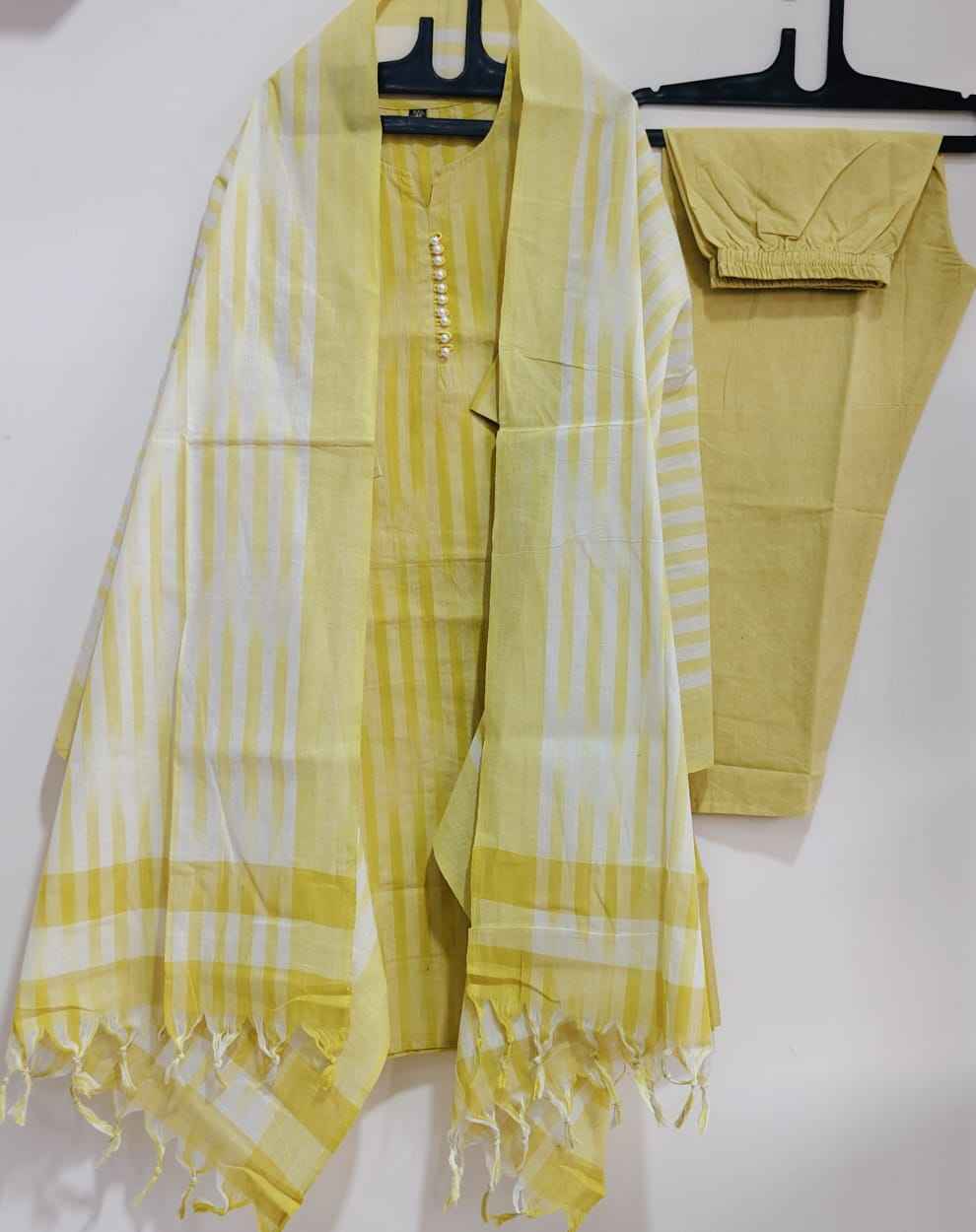 Close up view of traditional ethnic handloom south weaving patterns on a vibrant yellow cotton fabric surface.
