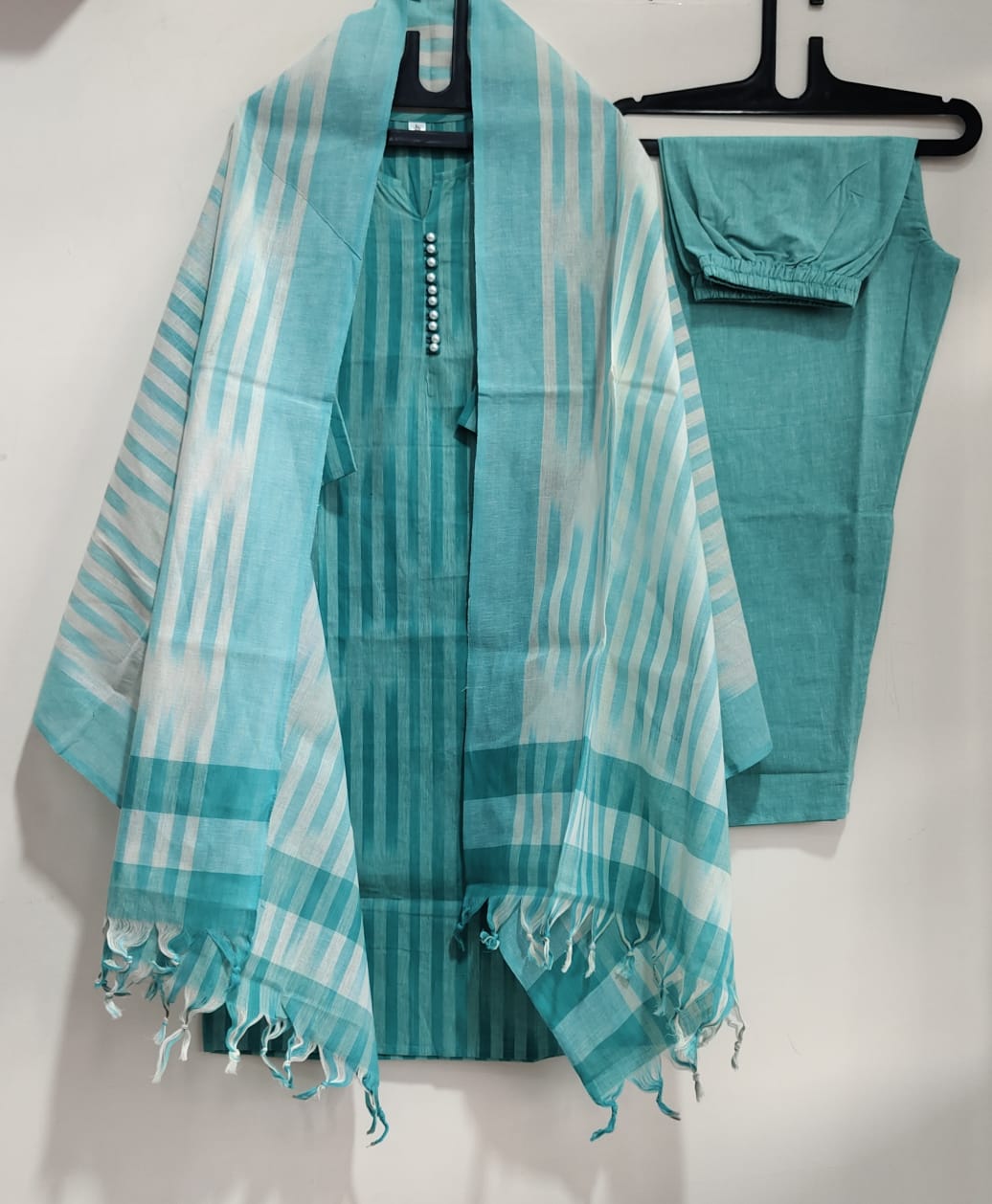 Close up view of traditional ethnic handloom south weaving patterns on a soothing sky blue cotton fabric surface.