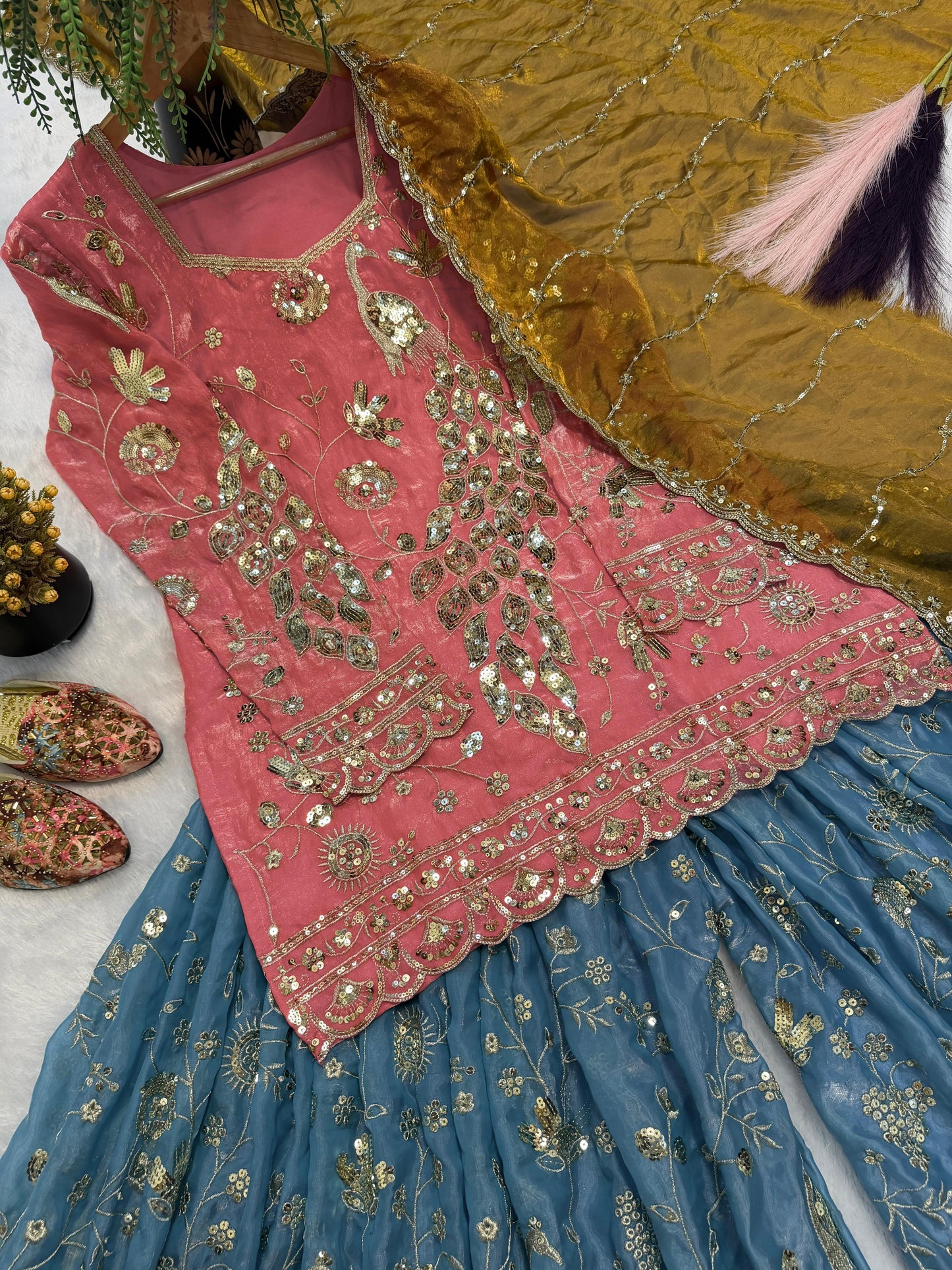 Close up view of detailed three millimeter and five millimeter sequence embroidery work patterns on a vibrant coral pink crushi silk bodice.