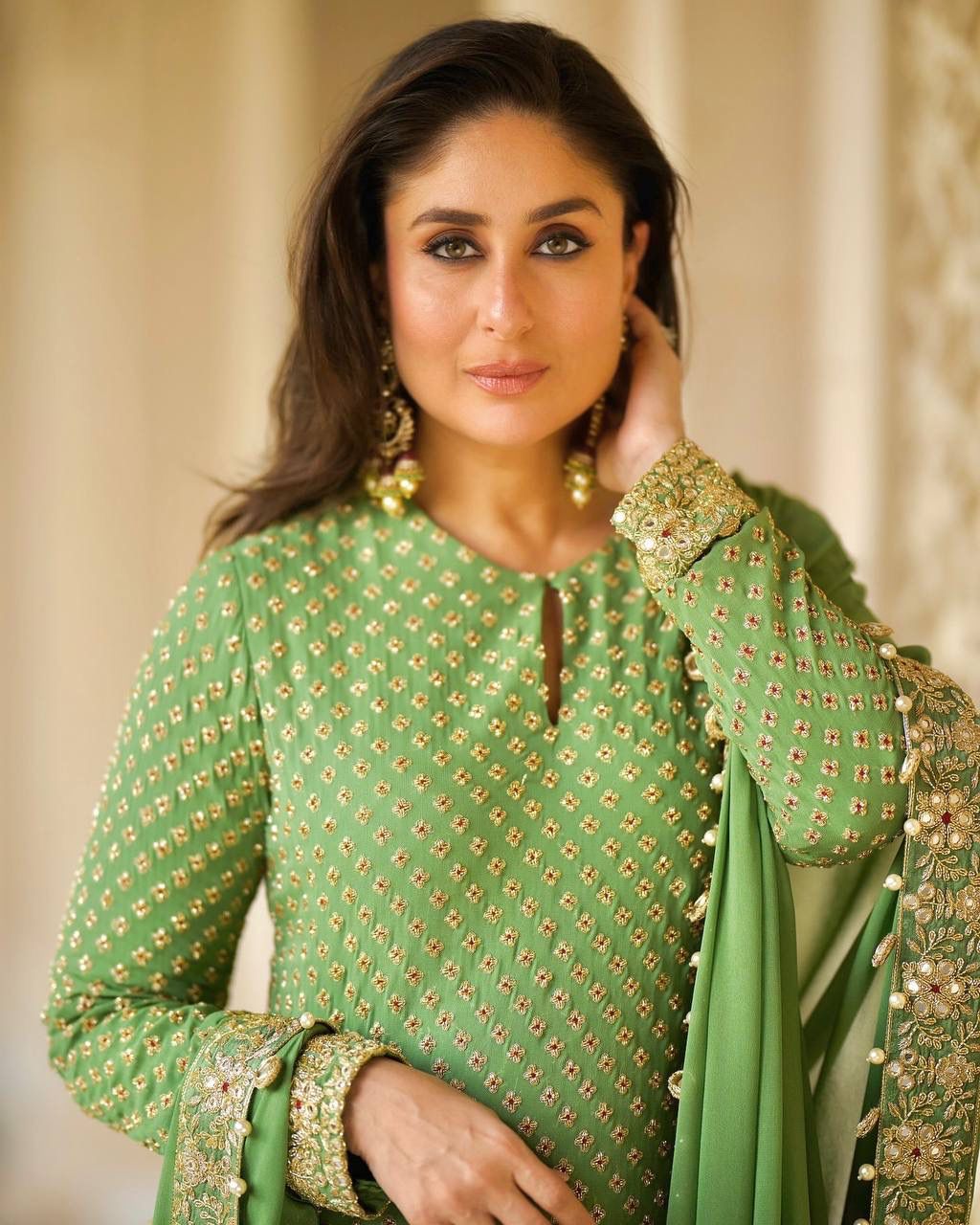 Front view of full three piece green traditional festive outfit displaying an embroidered faux georgette tunic top and matching palazzo trousers.