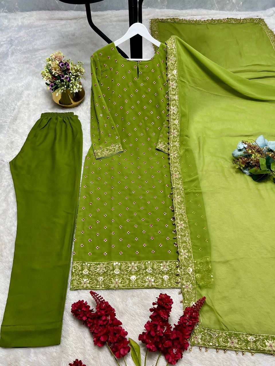 Side perspective of the fully stitched green ethnic dress highlighting the fluid georgette dupatta drape with readymade lace borders.