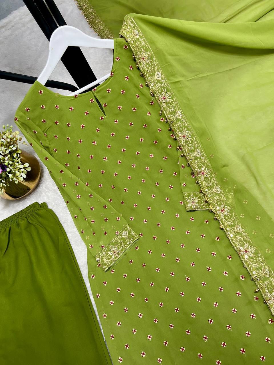 Macro view of the premium textile fabric surface displaying the high quality weave and subtle shine of green faux georgette material.