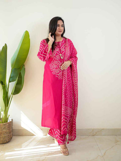 Close up view of traditional white bandhani discharge print dots and patterns on a vibrant dark pink cotton fabric base.