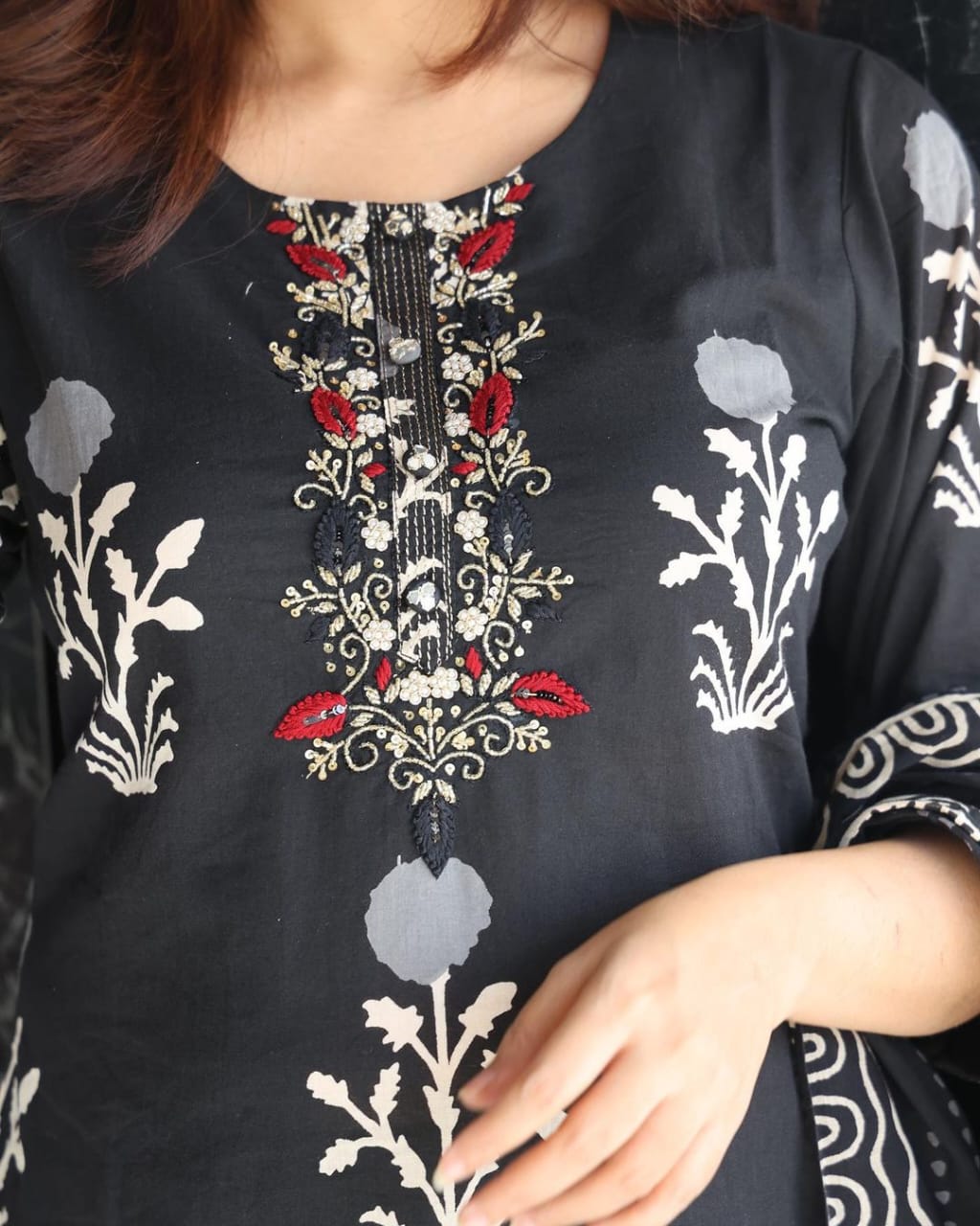 Side perspective presentation of the fully stitched black cotton tunic highlighting the straight fit style and forty six plus inch calf length profile.