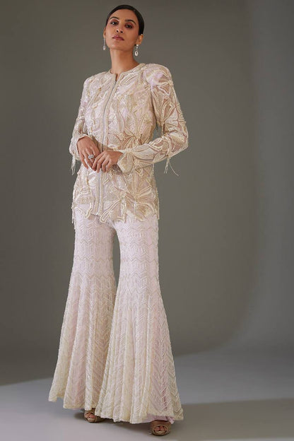 Front view of full two piece dusty rose traditional festive outfit displaying an embroidered georgette tunic top and matching sequence work palazzo trousers.