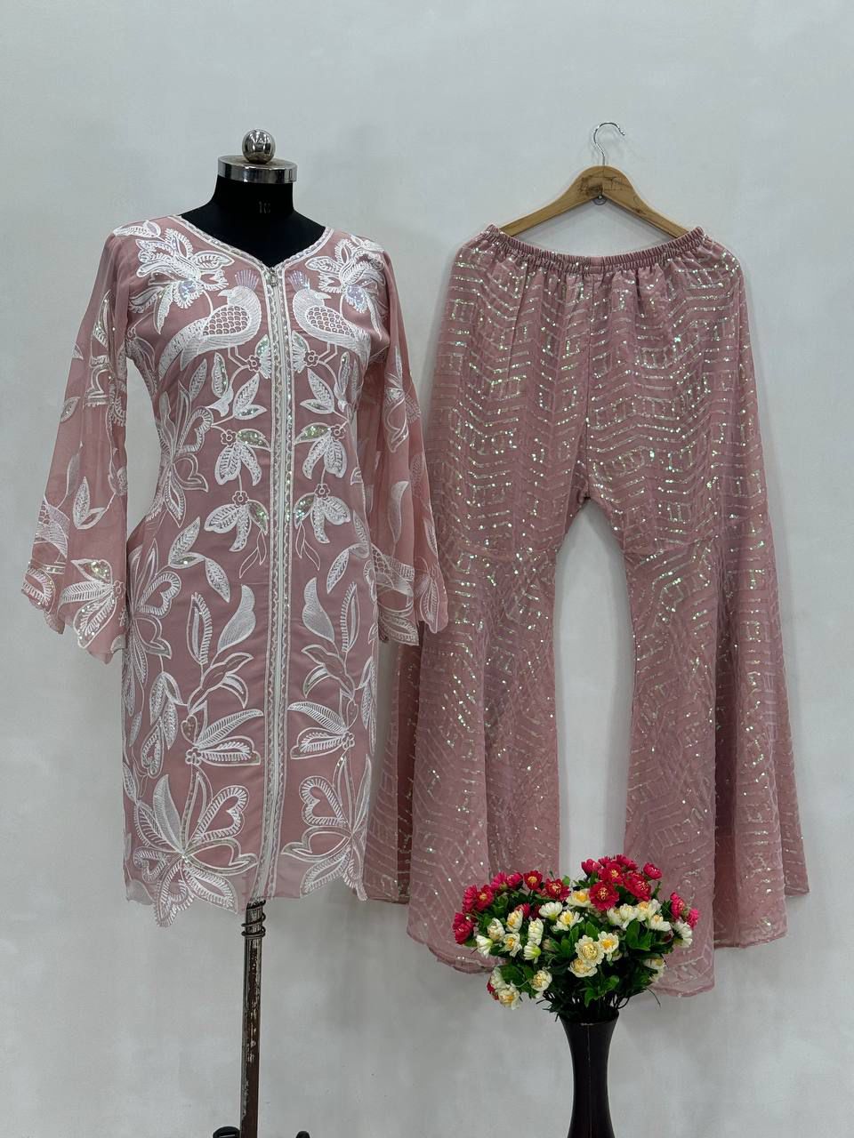 Side perspective of the dusty rose traditional dress highlighting the elegant full length sleeves covered in dense chine sequence embroidery.