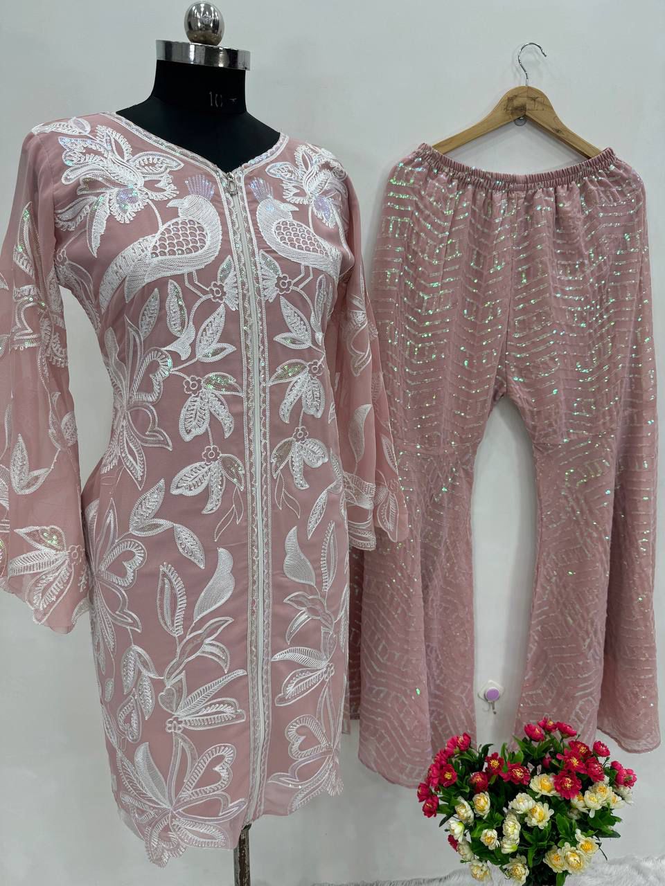 Close up view of detailed traditional heavy chine sequence work and shimmering needlework embroidery patterns on a rich dusty rose georgette bodice.