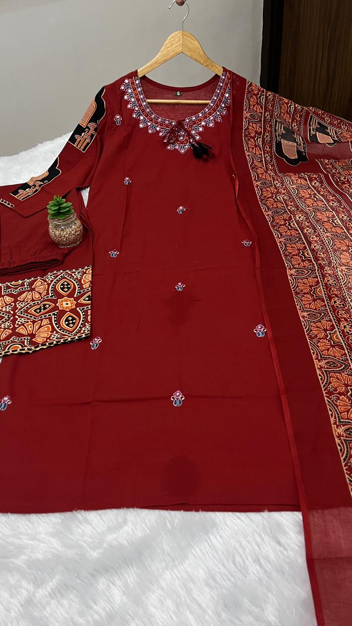 Close up view of detailed traditional neck full embroidery work and dense artisan thread patterns on a rich maroon cotton kurta bodice.