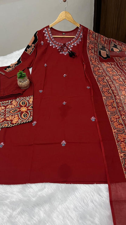Close up view of detailed traditional neck full embroidery work and dense artisan thread patterns on a rich maroon cotton kurta bodice.