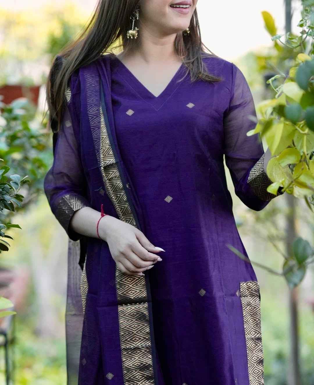 Close up view of authentic handwoven jamdani design motifs and intricate geometric loom patterns on a rich royal purple cotton fabric surface.