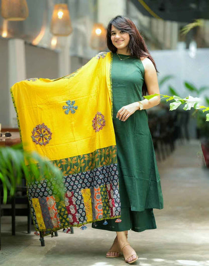 Front view of full three piece green handloom cotton a line kurta set displaying a sleeveless halter neck tunic palazzo pants and a cotton mulmul dupatta.