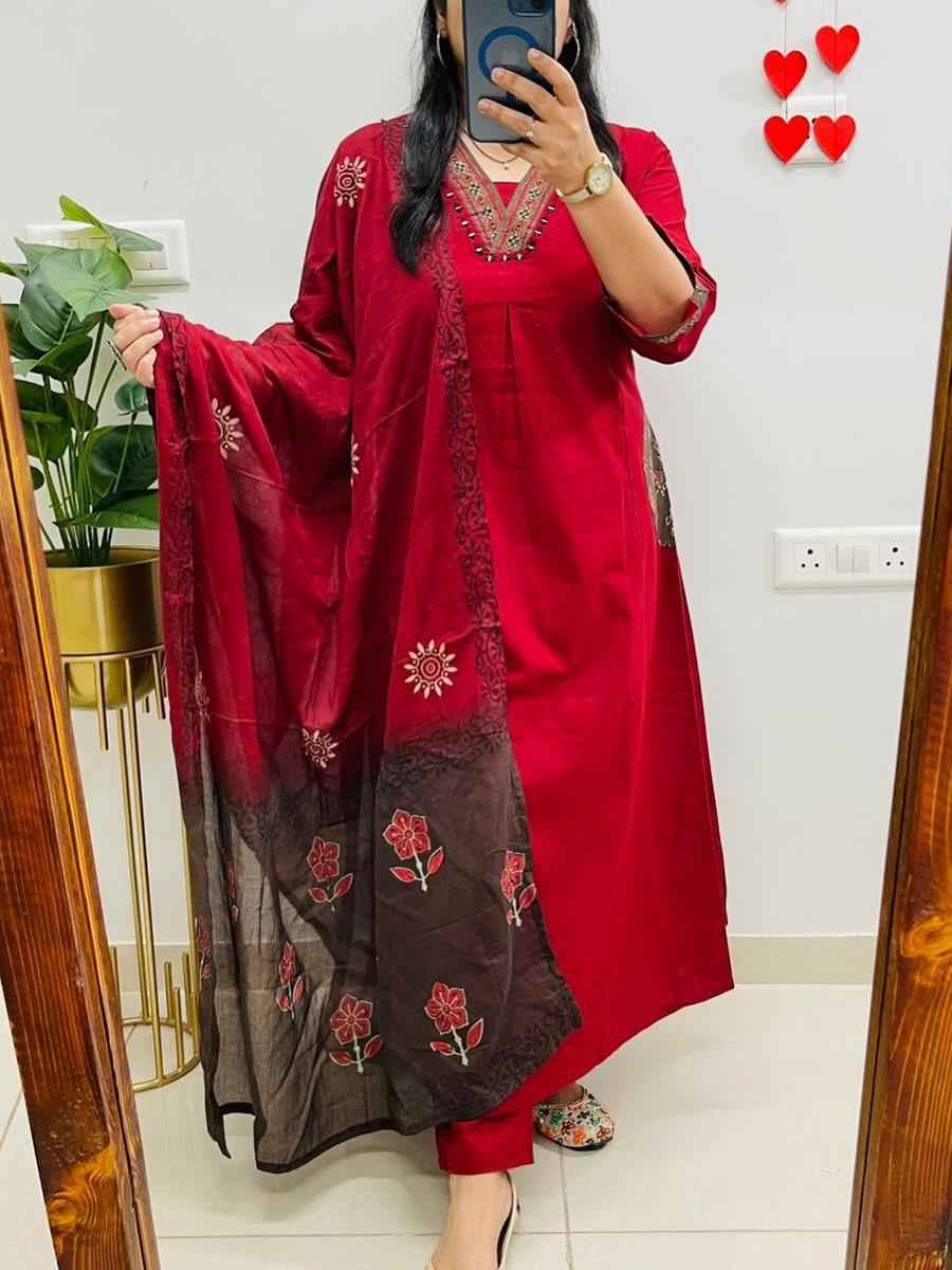 Front view of full three piece red pure cotton self print kurta set displaying a self printed tunic top straight pants and a mulmul printed dupatta.