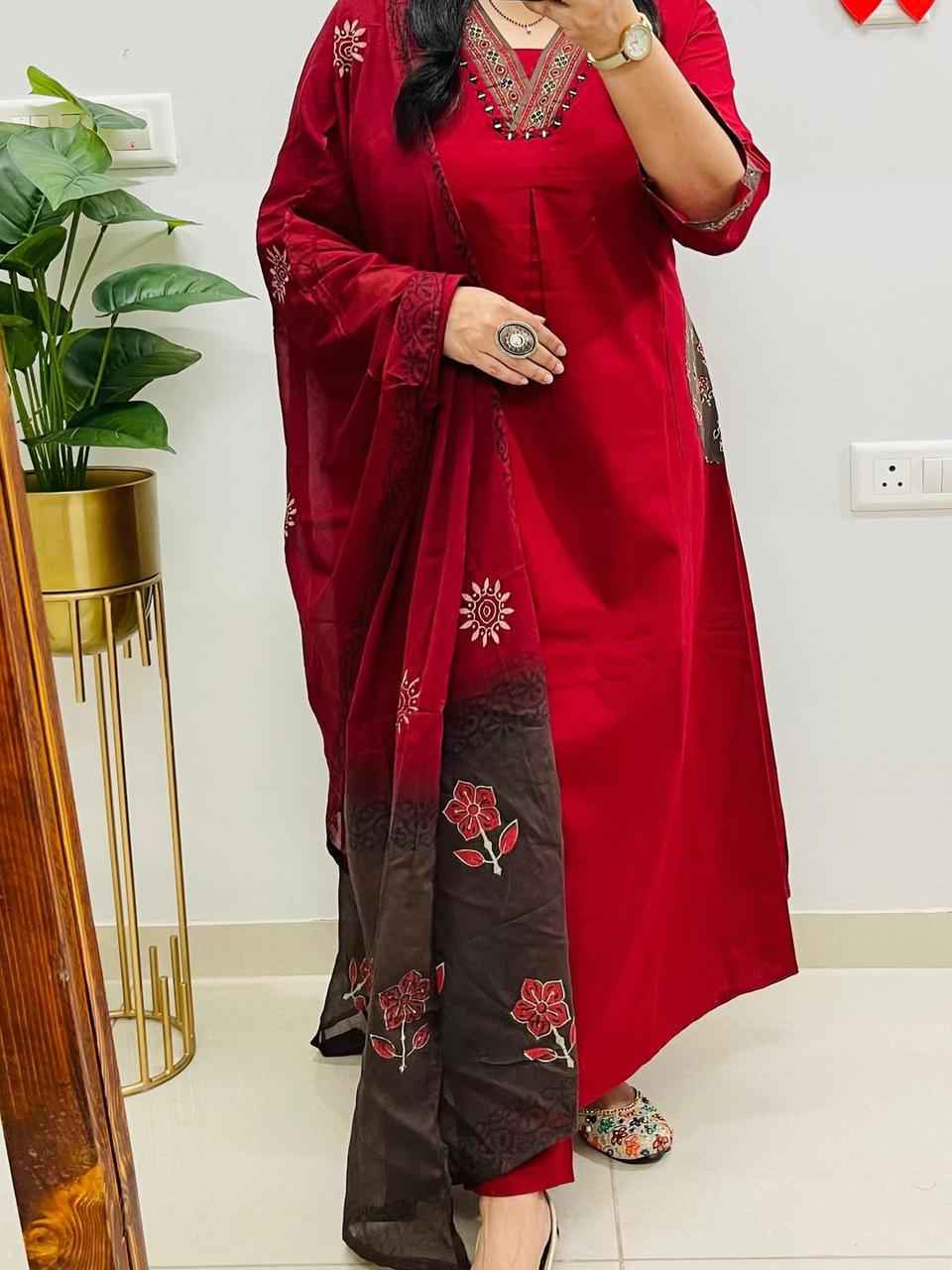 Close up view of detailed traditional self print motifs and fine neckline stitching lines on a rich red pure cotton fabric bodice.