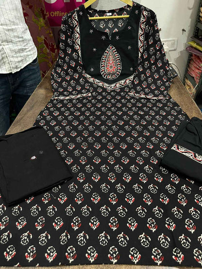 Close up view of detailed traditional hand work and premium intricate thread embroidery patterns on a rich solid black heavy cotton kurta bodice.