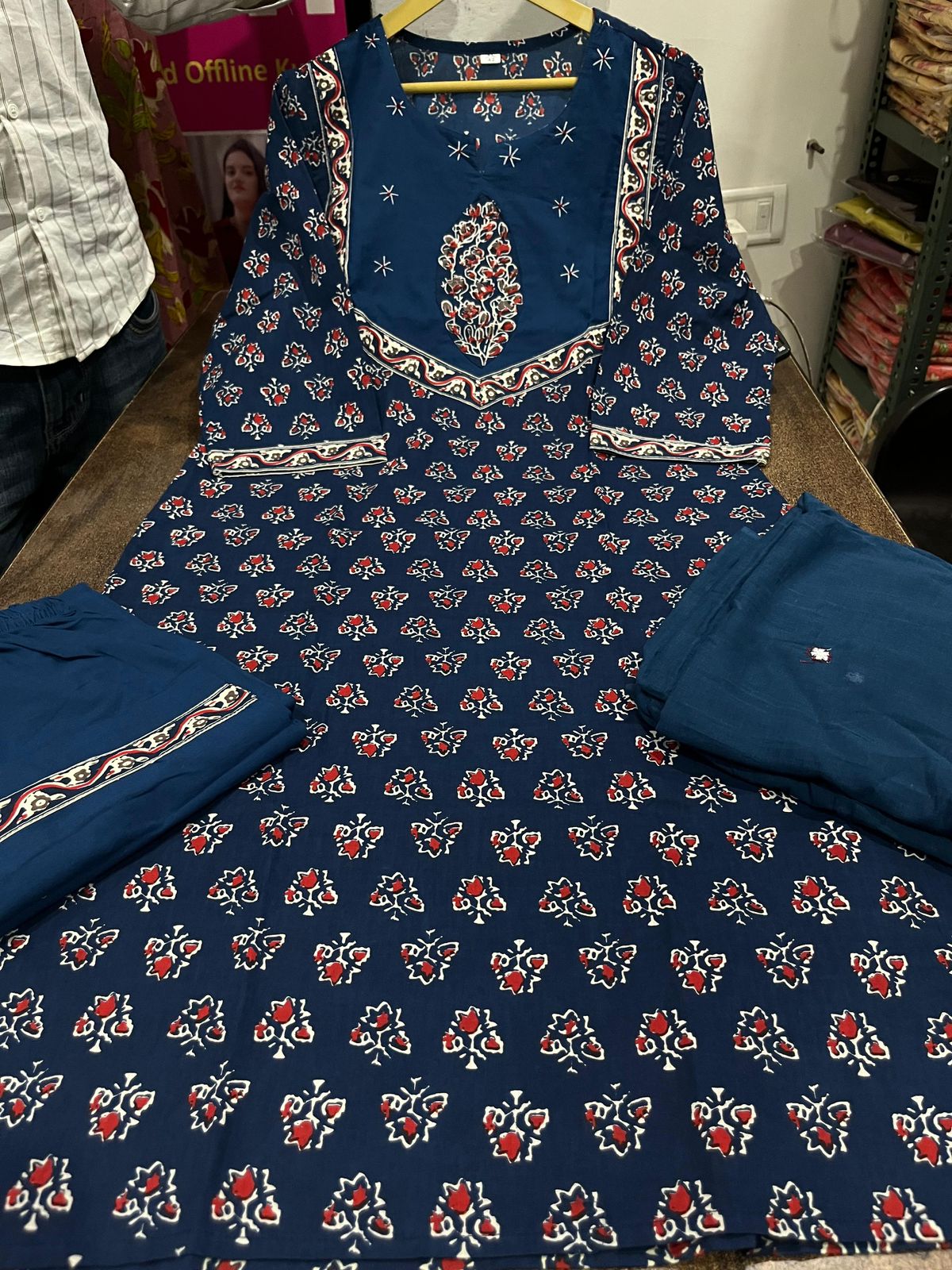 Close up view of detailed traditional hand work and premium intricate thread embroidery patterns on a deep navy blue heavy cotton kurta bodice.