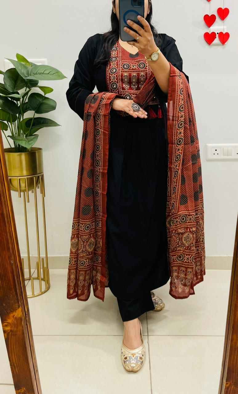 Front view of full three piece black heavy cotton hand work kurti set displaying a decorated straight tunic top matching pants and a light cotton dupatta scarf.