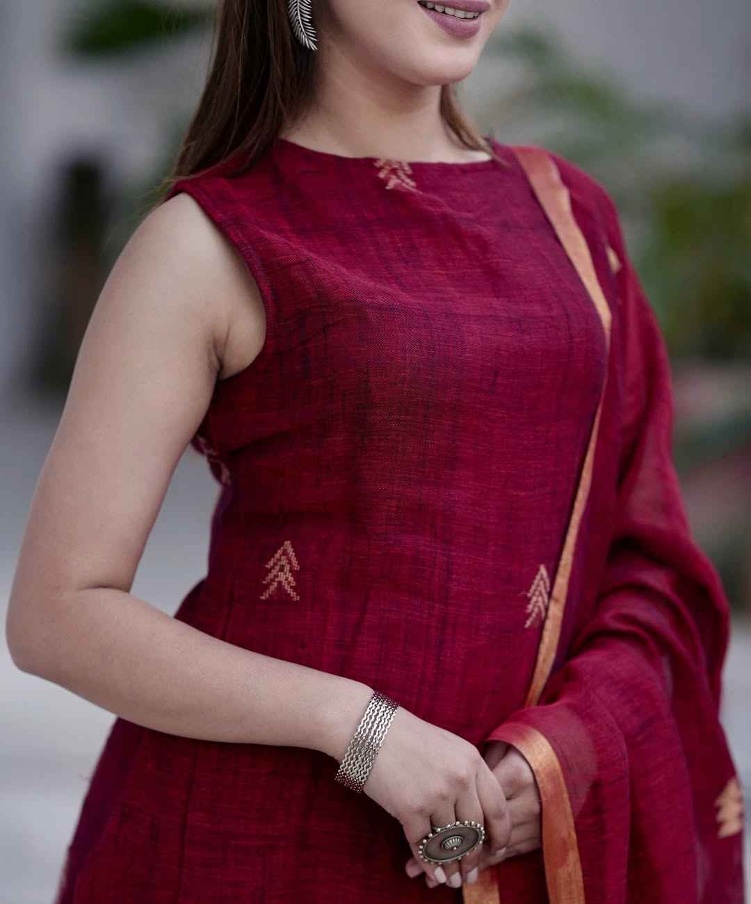 Close up view of the trendy halter neck collar design and clean structural stitching lines on a rich maroon cotton slub fabric bodice.