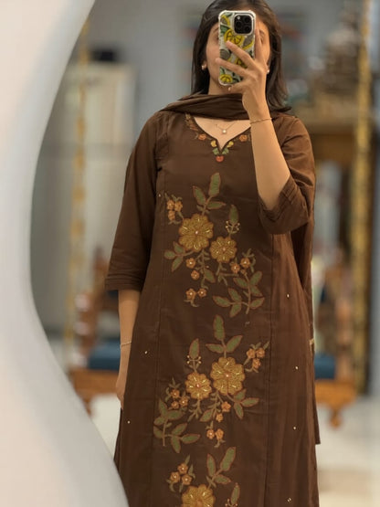 Close up view of detailed traditional  print motifs and premium heavy yoke embroidery work on a deep klosia brown cotton fabric bodice.