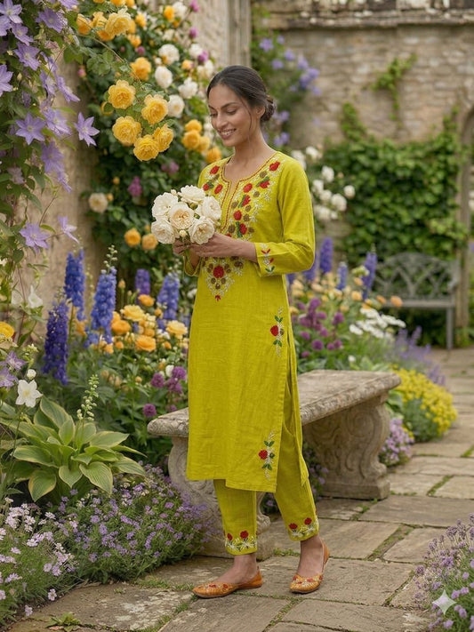 Front view of full two piece lemon green heavy aari work kurta set displaying a manually embroidered tunic top and wide leg palazzo trousers.