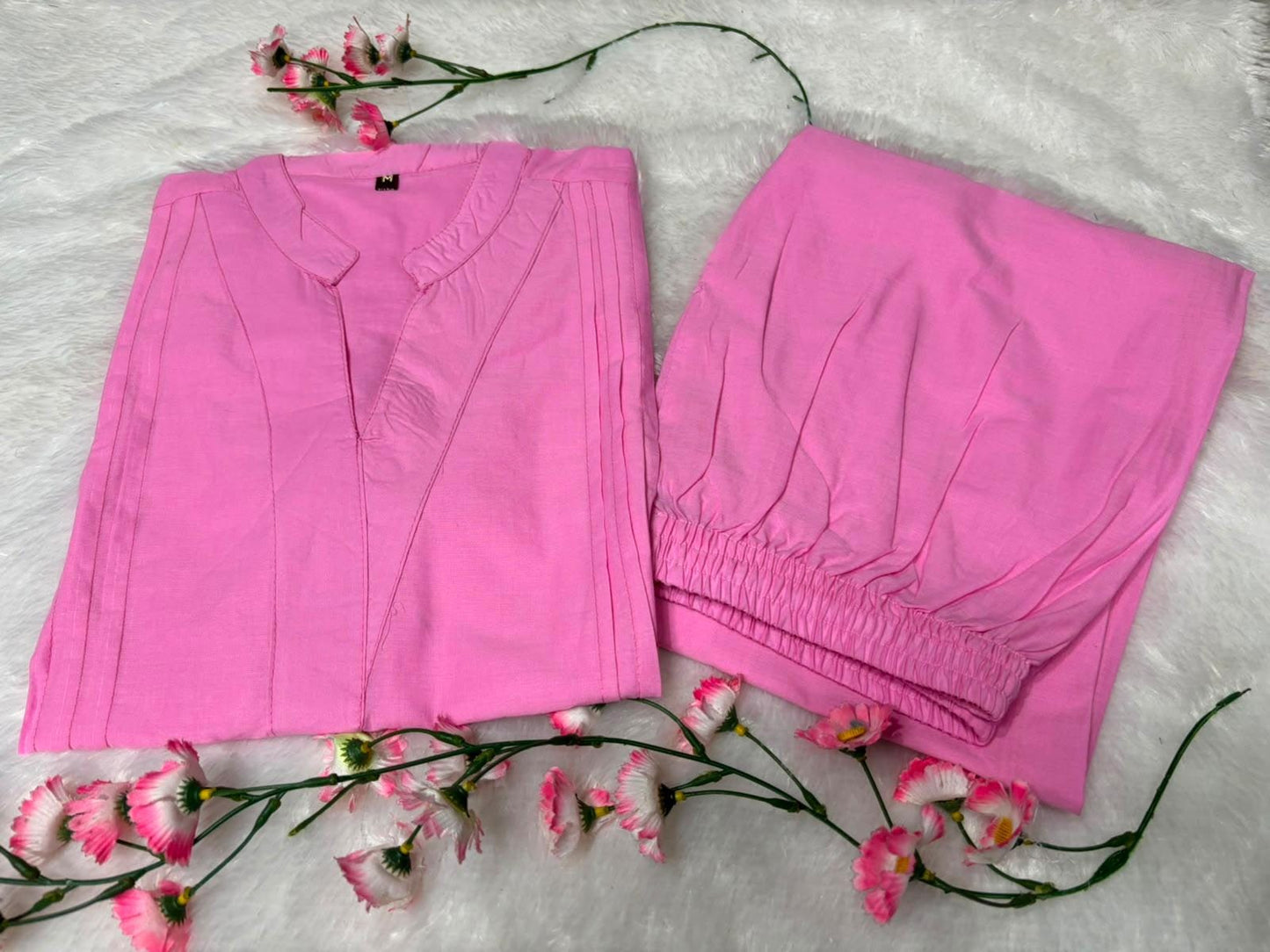 Close up view of detailed traditional embroidery work and high quality thread work patterns on a soft pink cotton fabric bodice canvas.