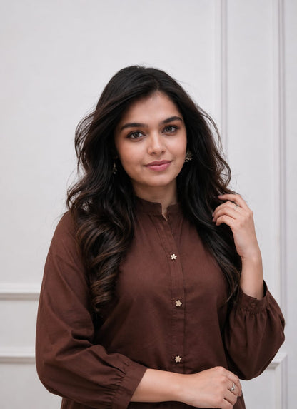 Close up view of detailed traditional embroidery work and high quality thread work patterns on a deep coffee brown cotton fabric bodice canvas.