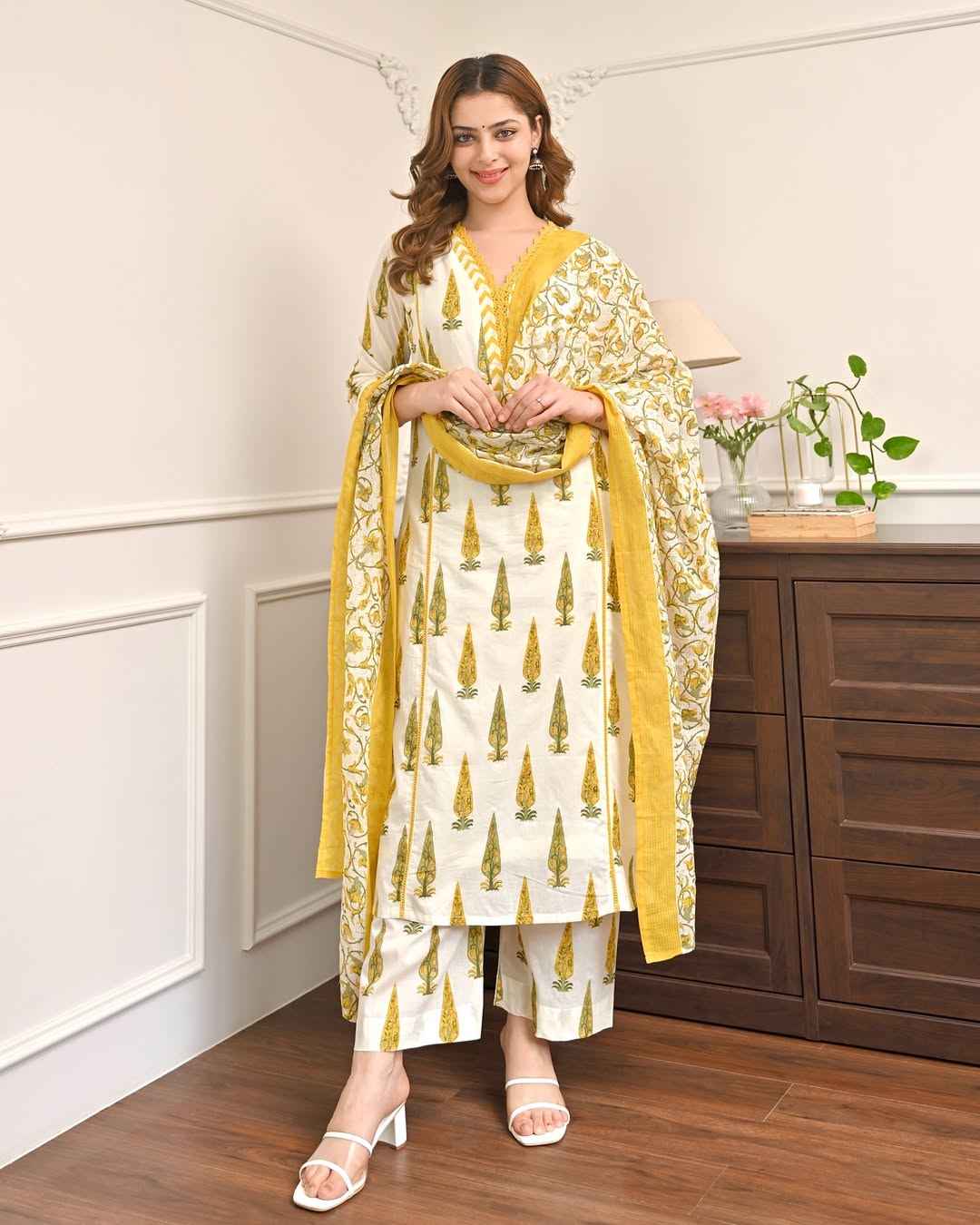 Front view of full lemon green Mughal printed 3 piece suit set displaying the lace work tunic printed trousers and matching mul cotton dupatta.
