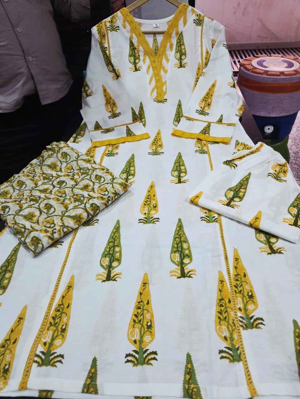 Detailed presentation of the lemon green sleeve cuffs showing the intricate lace borders and premium tailoring lines on the straight fit arm profile.
