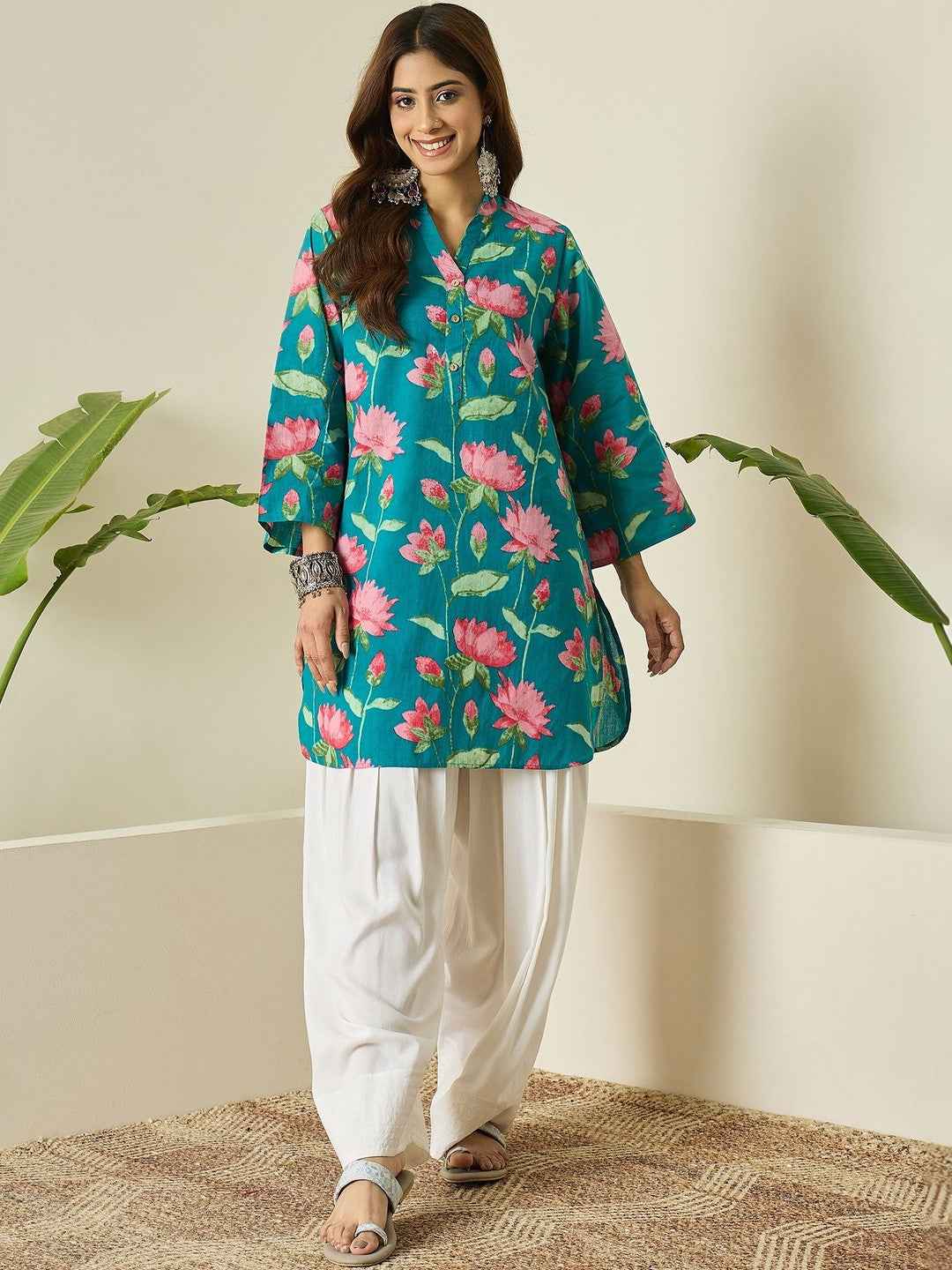 Front view of full two piece deep cyan breathable kurta farshi salwar set displaying a printed short tunic and flared trousers.